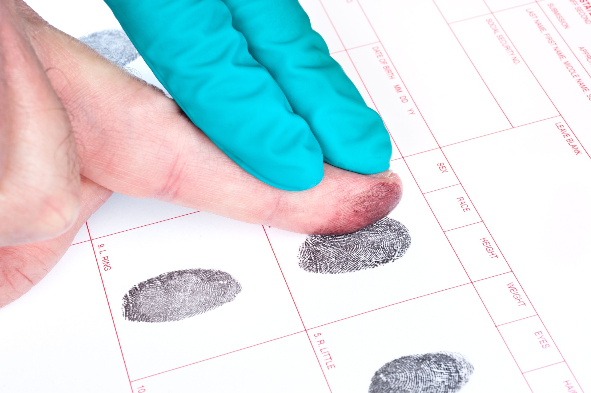 Man being finger printed with help of one other hand
