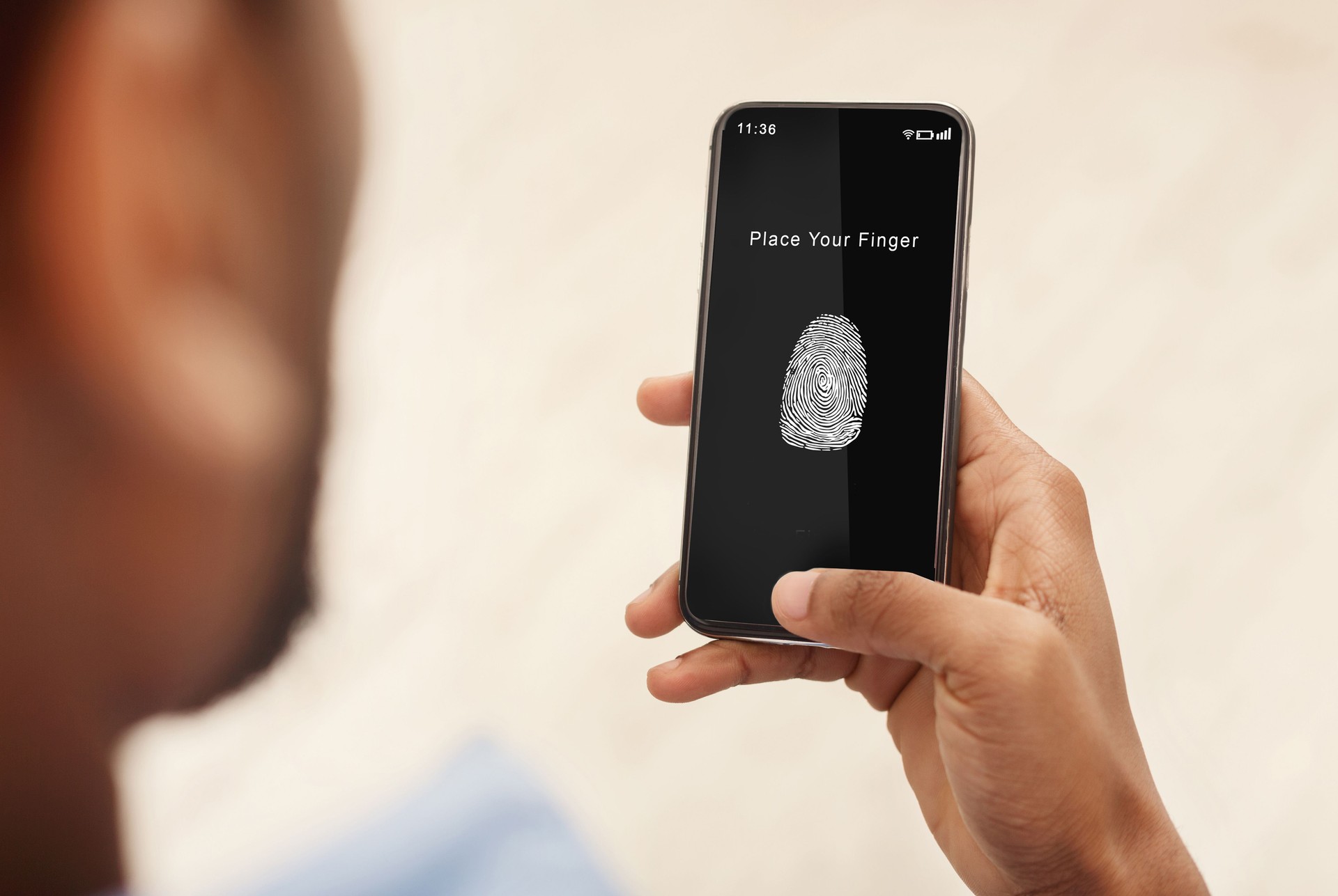 Man holding phone with fingerprint scanning app